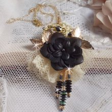 Pendentif Attrapes Rêves brodé avec des fleurs Lucites Noires sur une dentelle Beige et une estampe dorée. Les pendants sont des fleurs en cristal avec des rocailles. Monté avec une chaîne plaqué Or